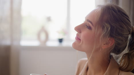 Woman-enjoys-cup-of-hot-drink-relaxing-in-office-after-work