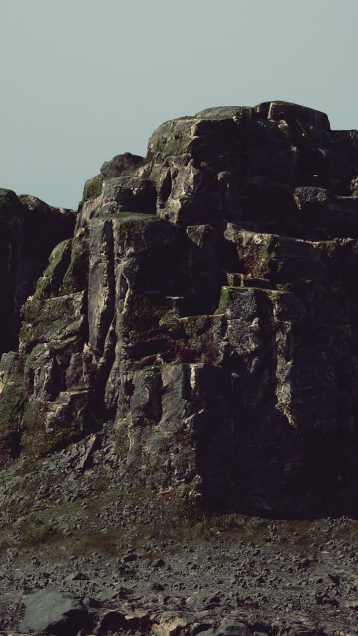 Majestic rock formations rise under a serene sky in a remote landscape