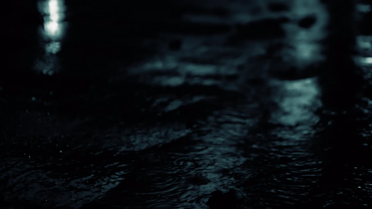 hermoso fondo de la lluvia nocturna, gotas gotean en un charco, la lluvia de la noche es negra y blanca