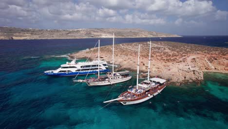 órbita-Aérea-Baja-Alrededor-Del-Barco-Pirata-Tradicional-Para-Una-Excursión-De-Un-Día-A-La-Laguna-Azul,-Malta