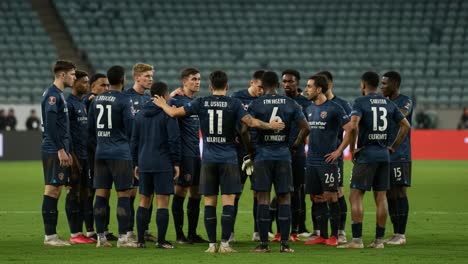 team huddle in focus: a strategic moment captured during a crucial match, highlighting unity and preparation among players as they discuss their game plan