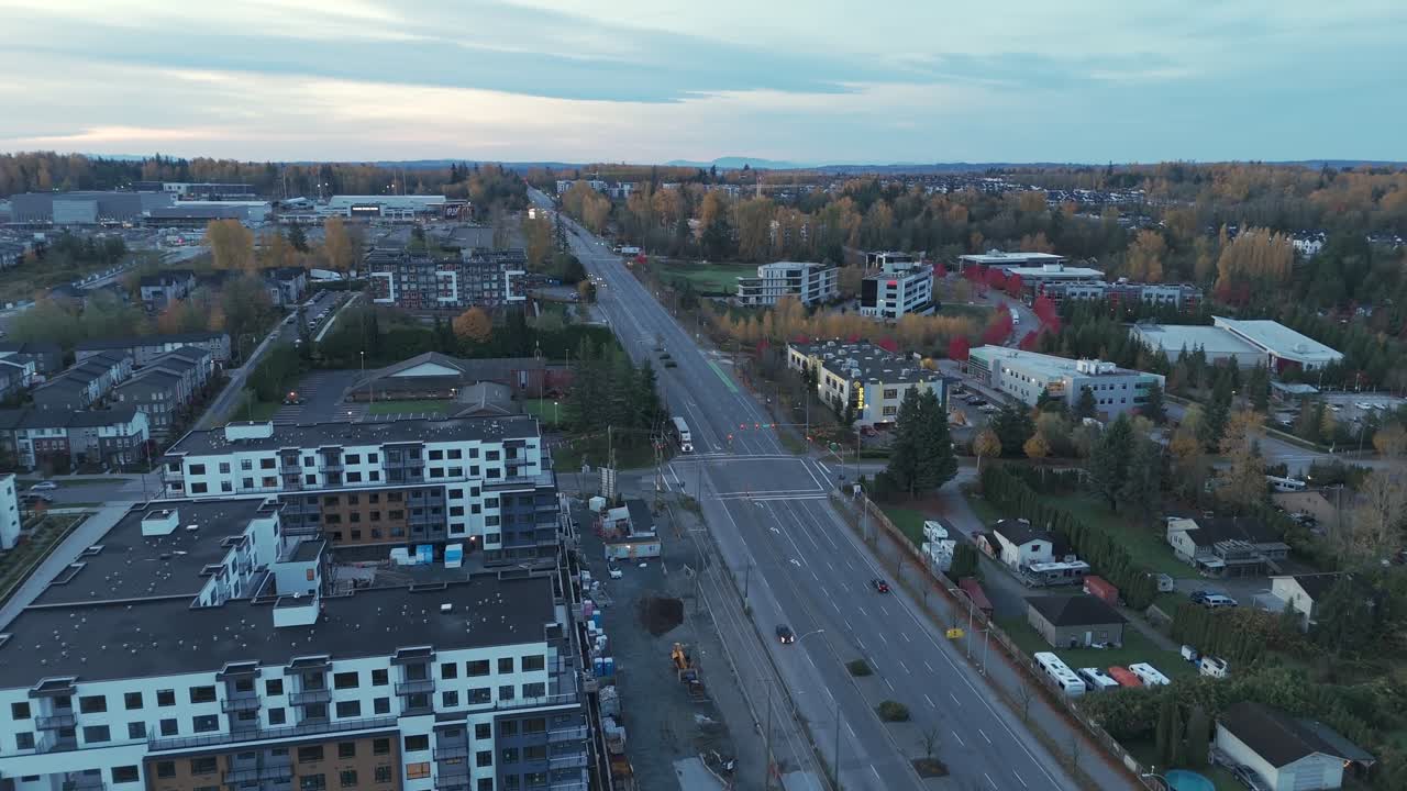 Carvolth, Langley City, Kanada – Modernit kerrostalot ja leveät tiet sijaitsevat puurivien keskellä muodostaen rauhallisen lähiöalueen pehmeän, pilvisen taivaan alla – Ilmakuva droonilla otettuna