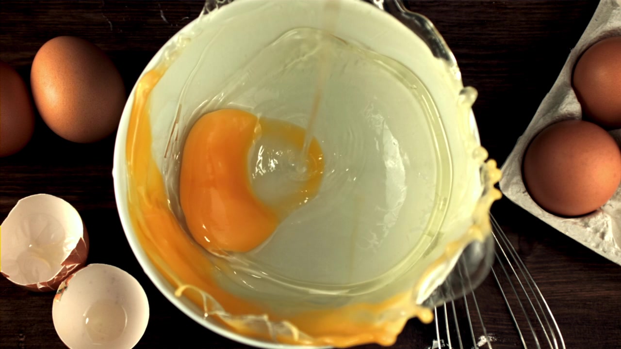 Slow Motion Egg Yolk and White Falling into a Bowl