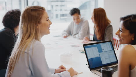 Team-Junger-Geschäftsfrauen-Mit-Laptop-Trifft-Sich-Am-Tisch-In-Einem-Modernen-Arbeitsbereich