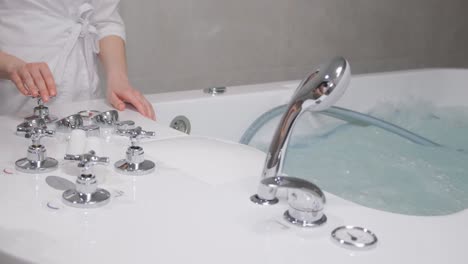 a woman enjoying a hydromassage in a jacuzzi. a relaxed woman receives a hydromassage from a professional beautician in a spa center.