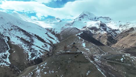 impresionante vista de la iglesia medieval de la trinidad de gergeti con el monte kazbek en el fondo en georgia