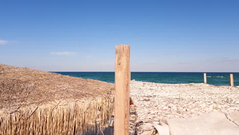 Techo-De-Paja-Y-Techo-De-Lona-Para-Sombra-En-Una-Playa-Cerca-Del-Mar