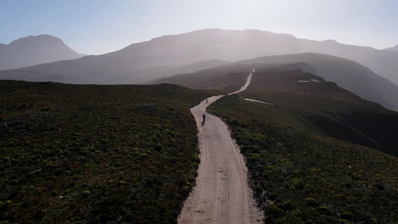 Cyclists ride on a stunning gravel road in the mountains of South Africa