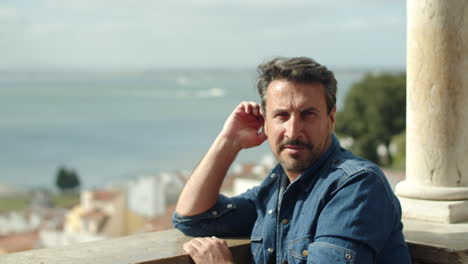 slow motion of man looking at city landscape from view point and then, looks to the camera