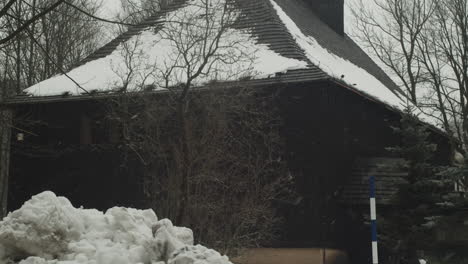 Snow-piles-around-St-John-the-Baptist-Church-in-Cesky-Jiretin-on-winter-day,-tilt