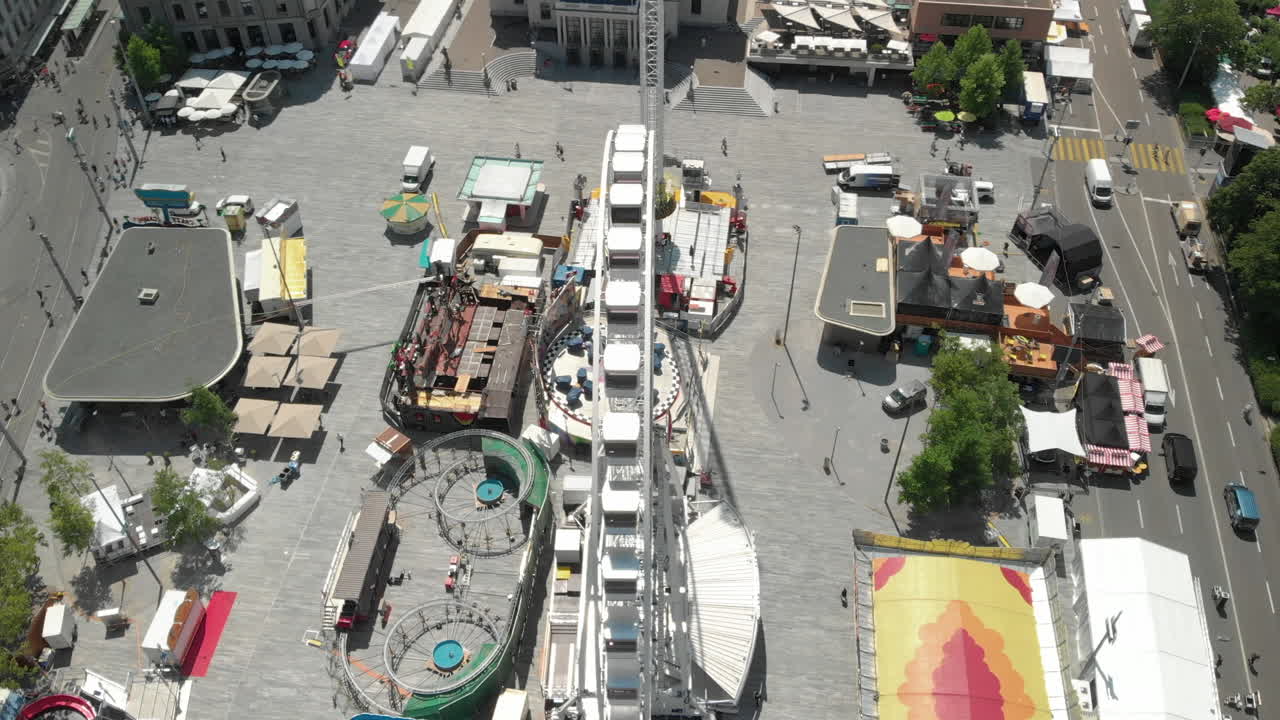 취리히 페스트 기간 동안 스위스 취리히 시를 배경으로 한 놀이공원 대관람차 주변에서 아름다운 360개의 공중 드론이 회전하고 상승합니다.