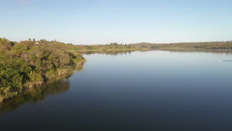 Low-Altitude-Forward-Flying-Shot-of-Inhampavala-Lake-in-Chindeguele-Mozambique-During-Golden-Hour-Sunrise