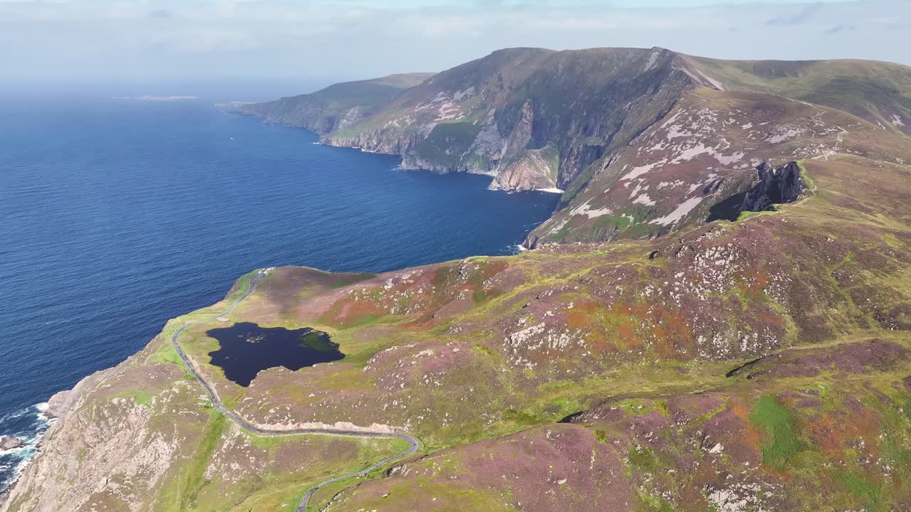 Aerial view of Slieve League cliffs, ocean, and green landscape in Ireland