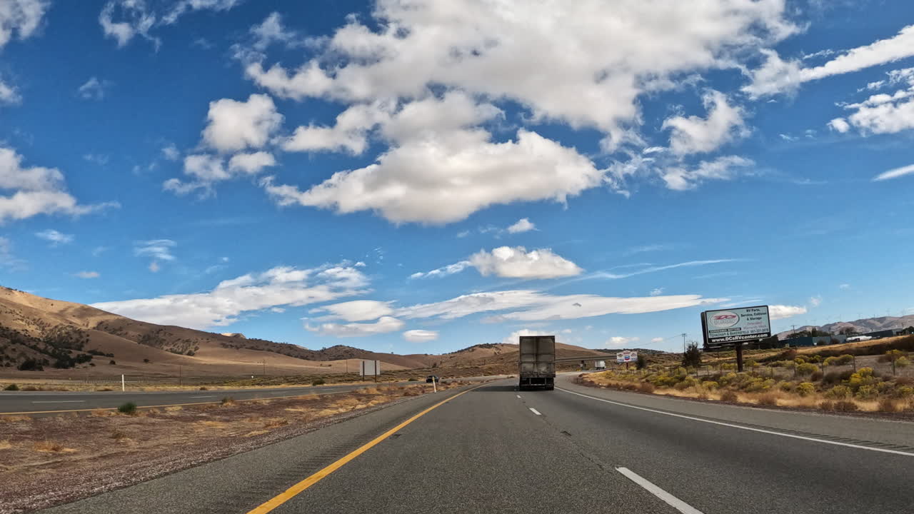 guidando lungo un'autostrada attraverso il deserto del mojave verso le montagne tehachapi
