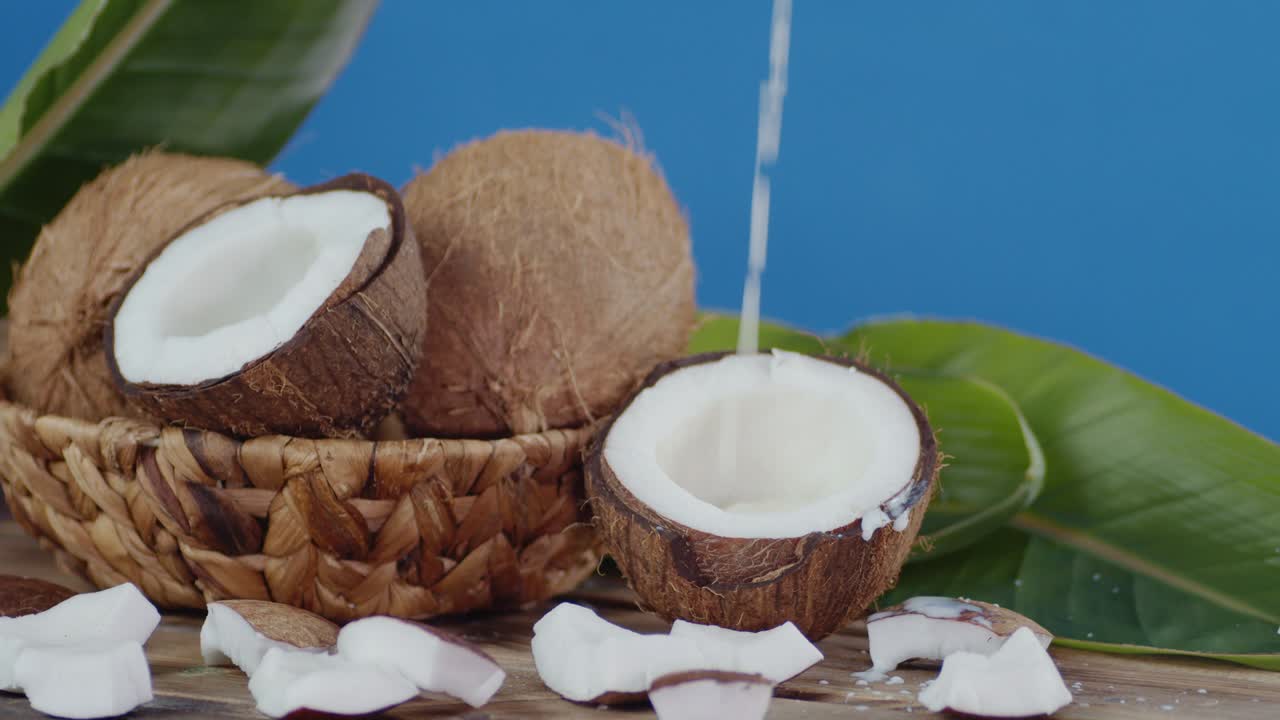 la leche de coco fluye lentamente en la mitad del coco.