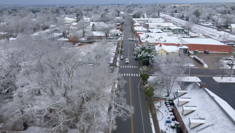 drone shot of small town main street usa after snowfall