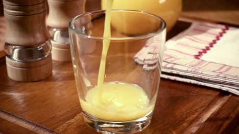 orange juice pouring into a glass, the morning breakfast. slow motion with rotation tracking shot.