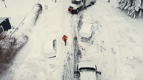 Luftaufnahme-Aus-Der-Vogelperspektive-Von-Einsatzkräften,-Die-Nach-Einem-Großen-Schneesturm-In-Schneebedeckten-Straßen-Arbeiten,-Während-Autos-Im-Schnee-Stecken-Bleiben