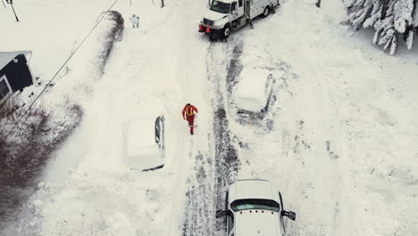 aerial birdseye view of emergency crews working in snow covered streets with cars stuck in the snow after a large snow storm