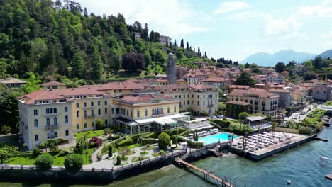 elevated shot of bellagio's elegant waterfront buildings beneath forested hills. lake como, italy