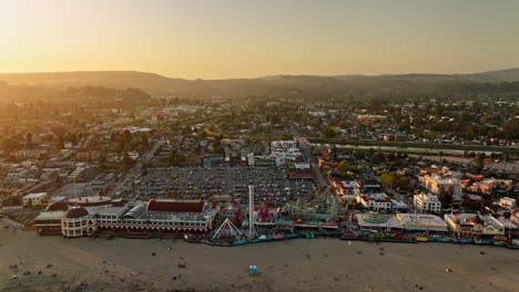 santa cruz california aerial v12 panoramic panning view flyover beach boardwalk amusement park capturing glowing sun shinning across townscape and san lorenzo river - shot with mavic 3 cine - may 2022