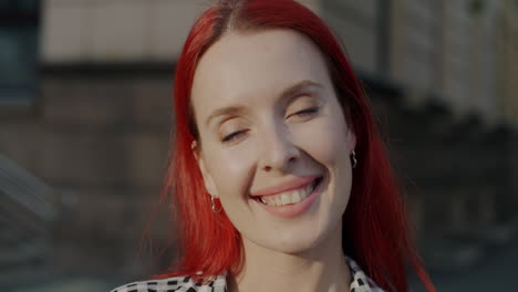 woman with red hair smiling in the city