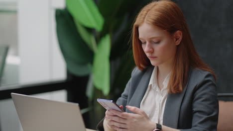 Die-Buchhalterin-Eines-Modernen-Unternehmens-Arbeitet-Im-Büro-Und-Liest-Nachrichten-Im-Mobiltelefon-Und-Surft-Im-Internet