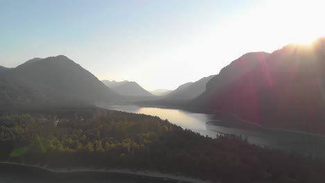 a-professional-looking-aerial-shot-of-the-austrian-alps,-while-golden-hour,-flying-right-towards-the-warm-sun