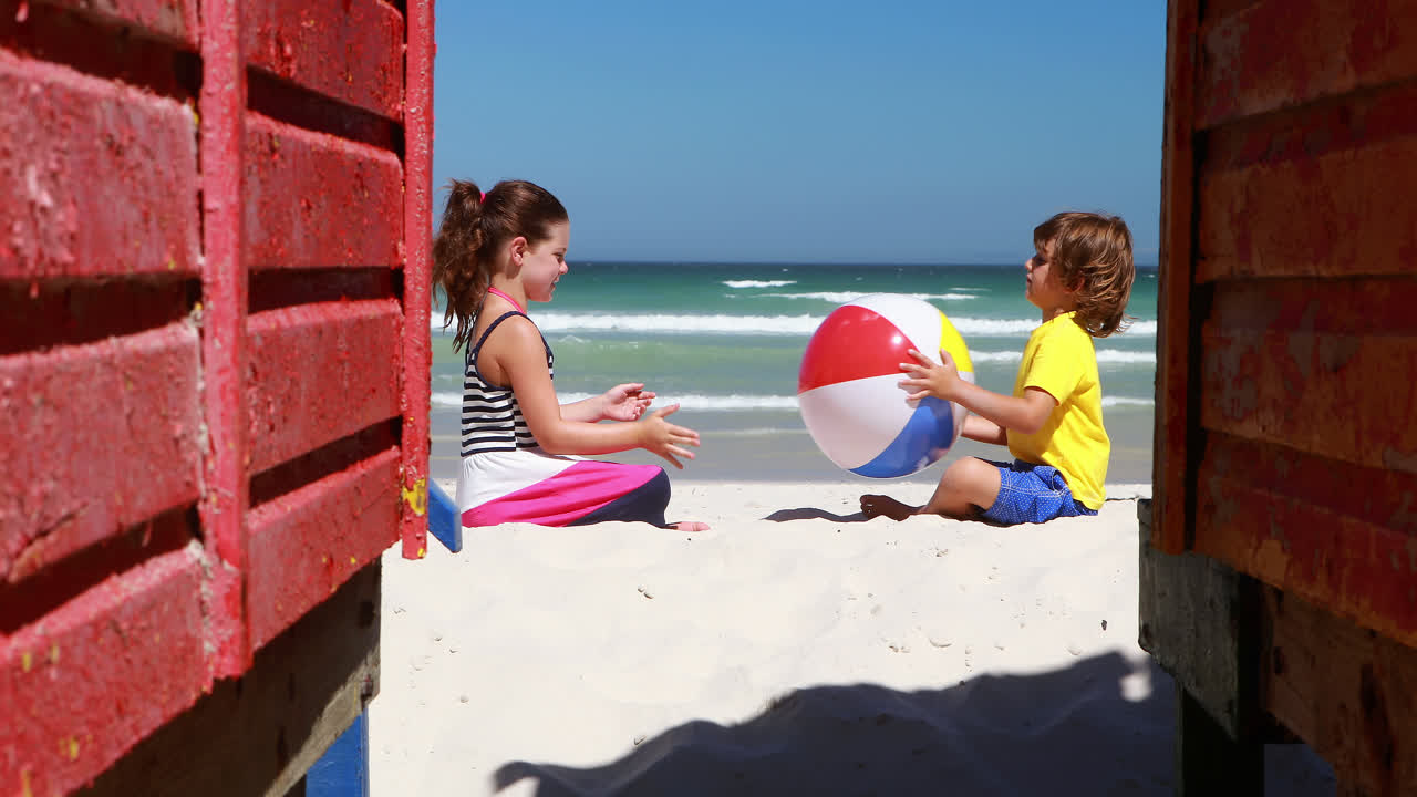 hermanos jugando en la playa en un día soleado