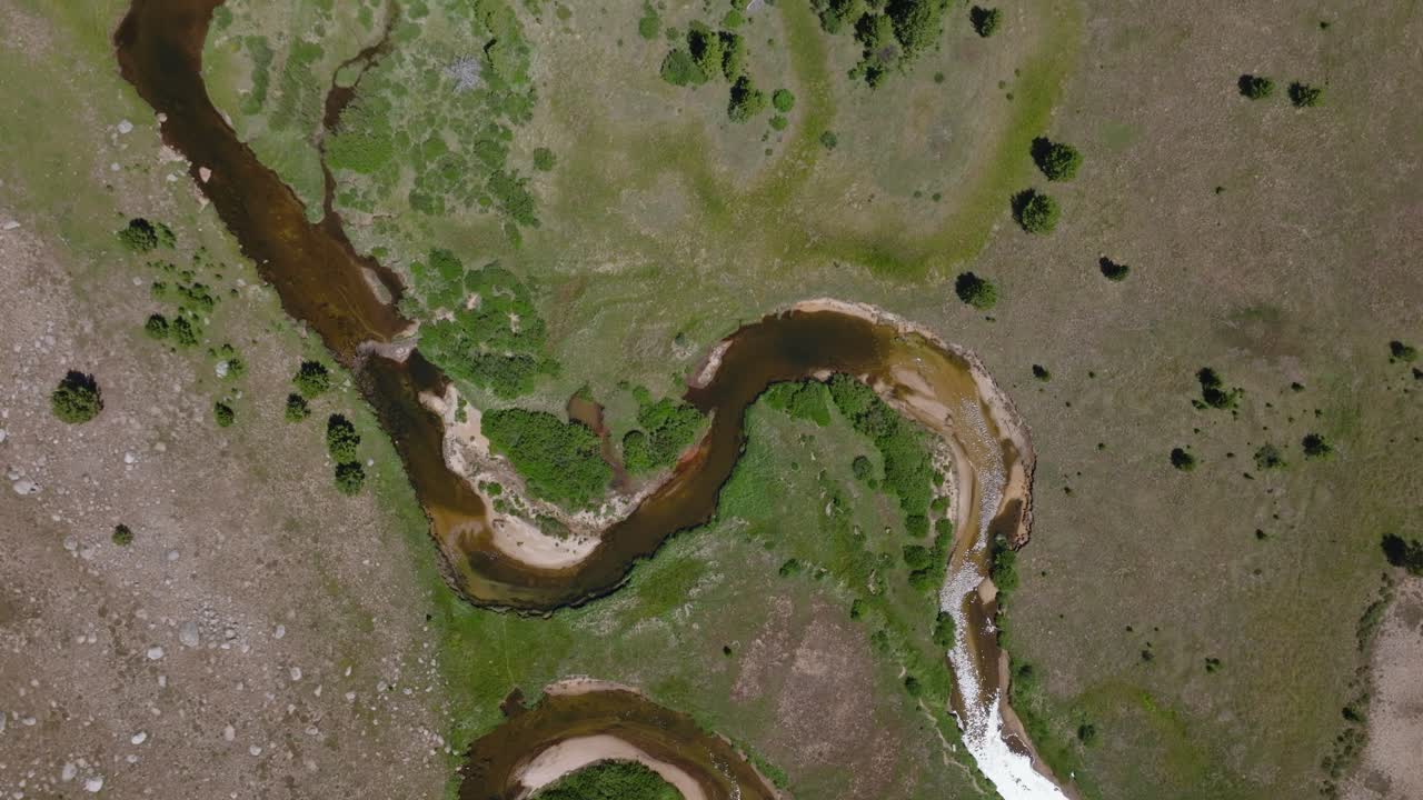 Aerial top down bird's eye view of the Big Sandy Trailhead, Wind River Wilderness, Wyoming, with lush green plains, winding rivers, and distant mountains