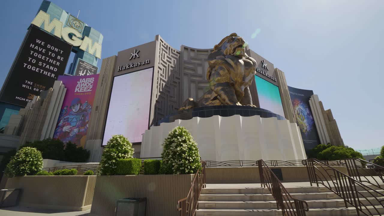 The golden MGM lion stands on its platform, isolated on the Las Vegas Strip. No pedestrians in sight in the empty Strip sidewalk.