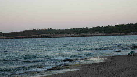 waves from the ocean end on the shore of the beach during the sunset