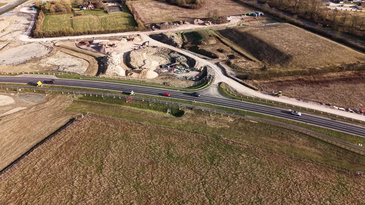 Traffic moves on Waddesdon A41 road roundabout, aerial view, daylight