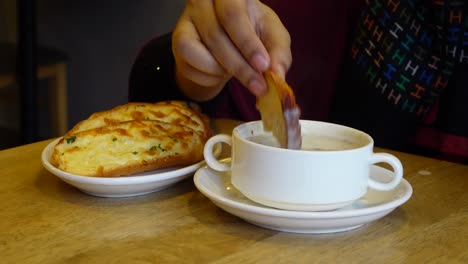 mujer disfrutando de sopa y pan de ajo