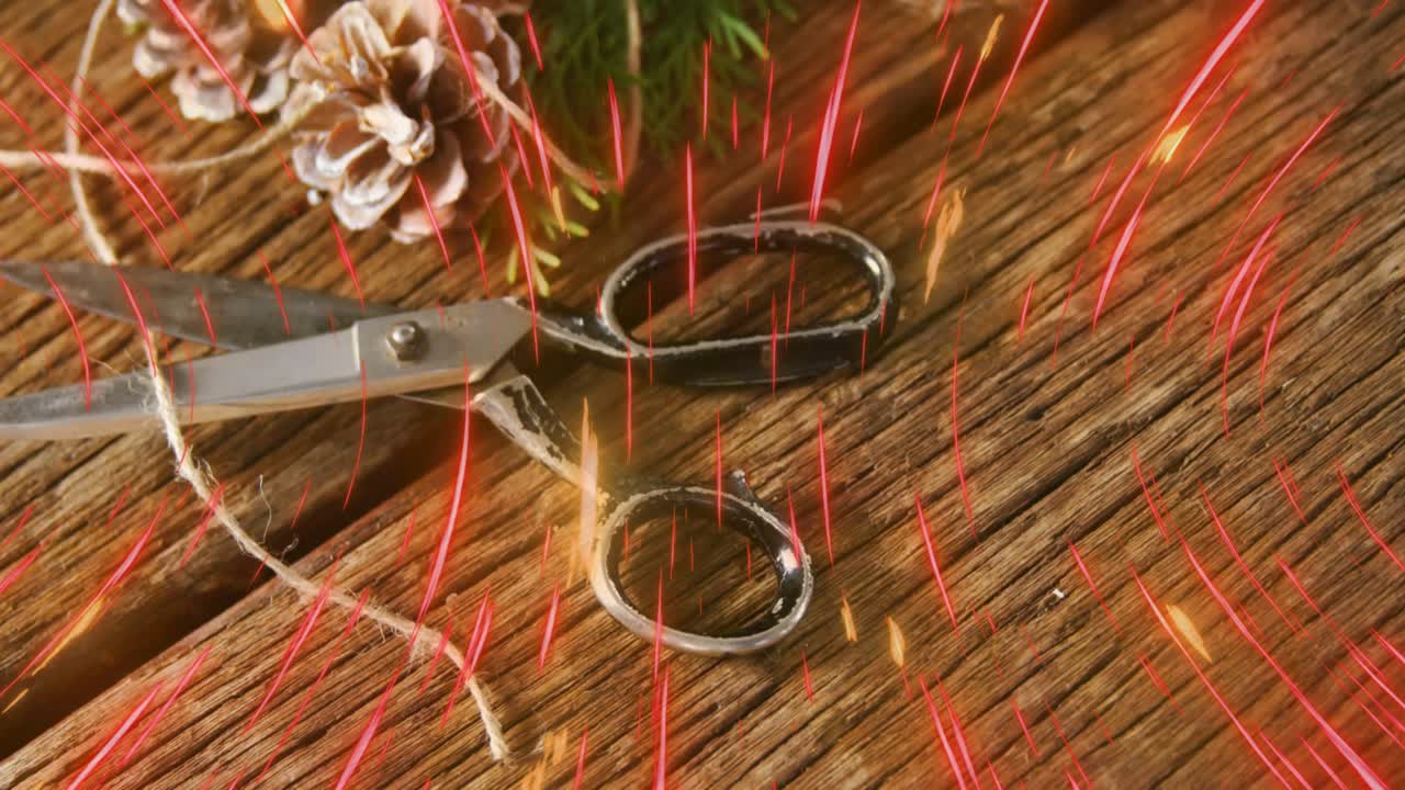 Red streaks emerging at top falling over tabletop showing scissors pine cones sprigs before fading