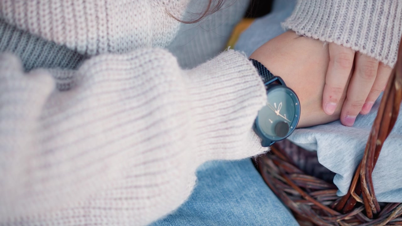 Primo piano di una donna che indossa un orologio e un maglione di lana