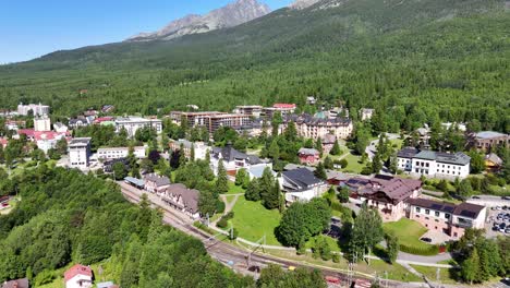beautiful drone footage of starý smokovec in slovakia's high tatras. shows mountain peaks, forests, and clear skies on a calm summer day