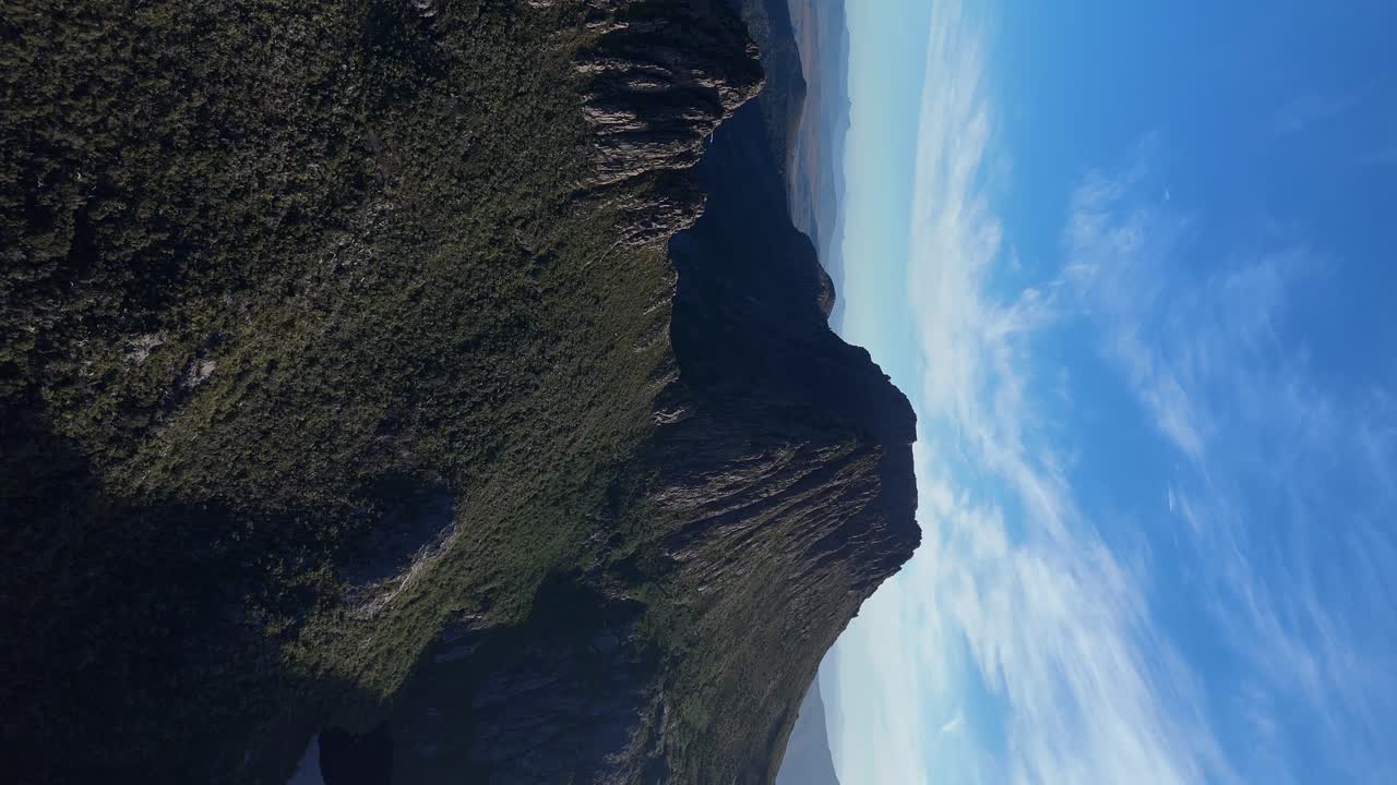 Vertical drone shot of famous Cradle Mountain World Heritage area of Tasmania. Sunny day with blue sky between landscape. Wide shot.