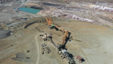 Aerial-View,-Lignite-Coal-Open-Pit-Mine-and-Heavy-Machinery-on-Sunny-Day,-Orbit-Drone-Shot-50fps