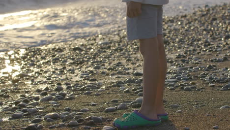 child's legs on the beach at sunset