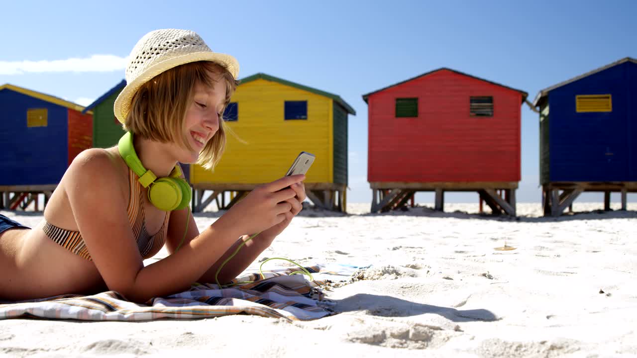 chica usando teléfono móvil en la playa 4k