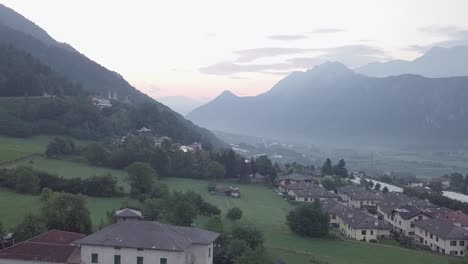 Aerial-view-of-Levico-Terme,-Italy-,-during-sunrise-with-drone-rising