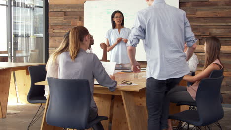 young black woman giving presentation to business colleagues