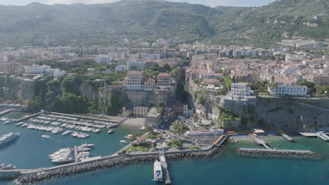 Empuje-Aéreo-Lento-Hacia-Los-Acantilados-De-Sorrento-Con-El-Mar-Y-El-Puerto-En-Primer-Plano-En-Italia