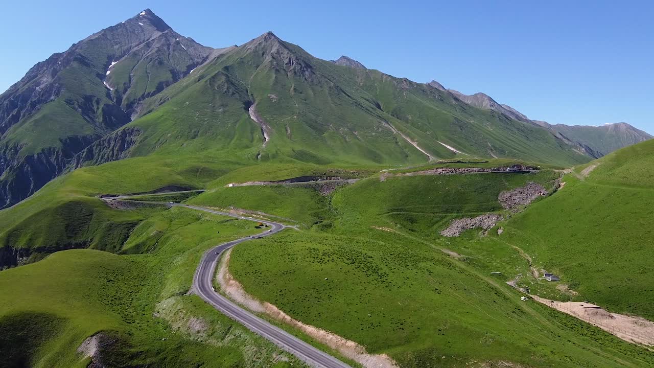 toma aérea cinematográfica que se acerca desde una carretera y montañas en georgia mientras pasan los autos