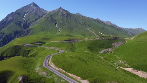 cinematic aerial shot zooming in from a highway and mountains in georgia while cars are passing