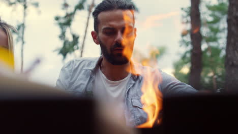 hombre serio usando herramientas de cocina afuera. tipo preparando comida de barbacoa al aire libre