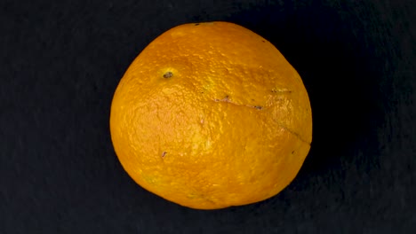 rotating orange fruit on a black background, showing vibrant texture and color