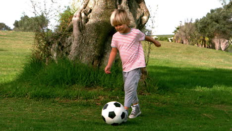 child dribbling with the football