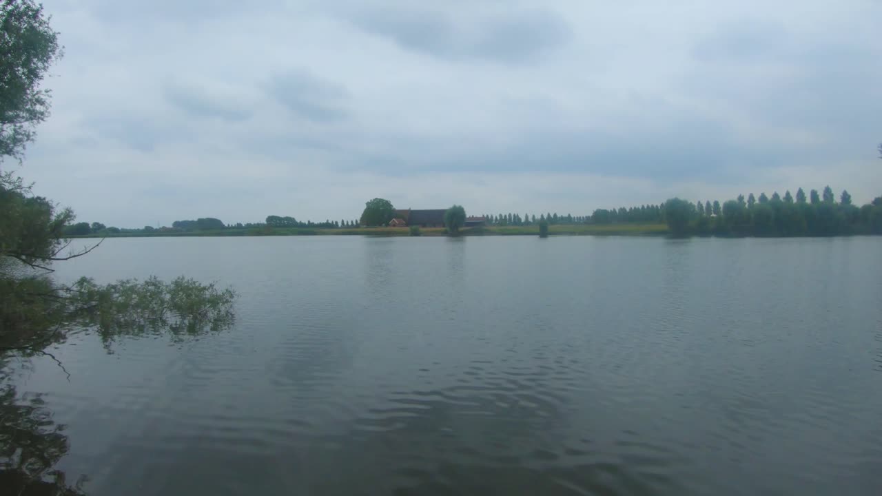 zwaakse weel, 's-gravenpolder, zeeland, 네덜란드, 지평선에 오래된 농장이 있는 평화로운 물의 slowmo 4k 영상